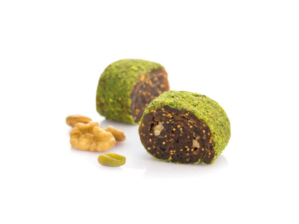 Lokum roulé aux figues et aux noix, saupoudré de poudre de pistache